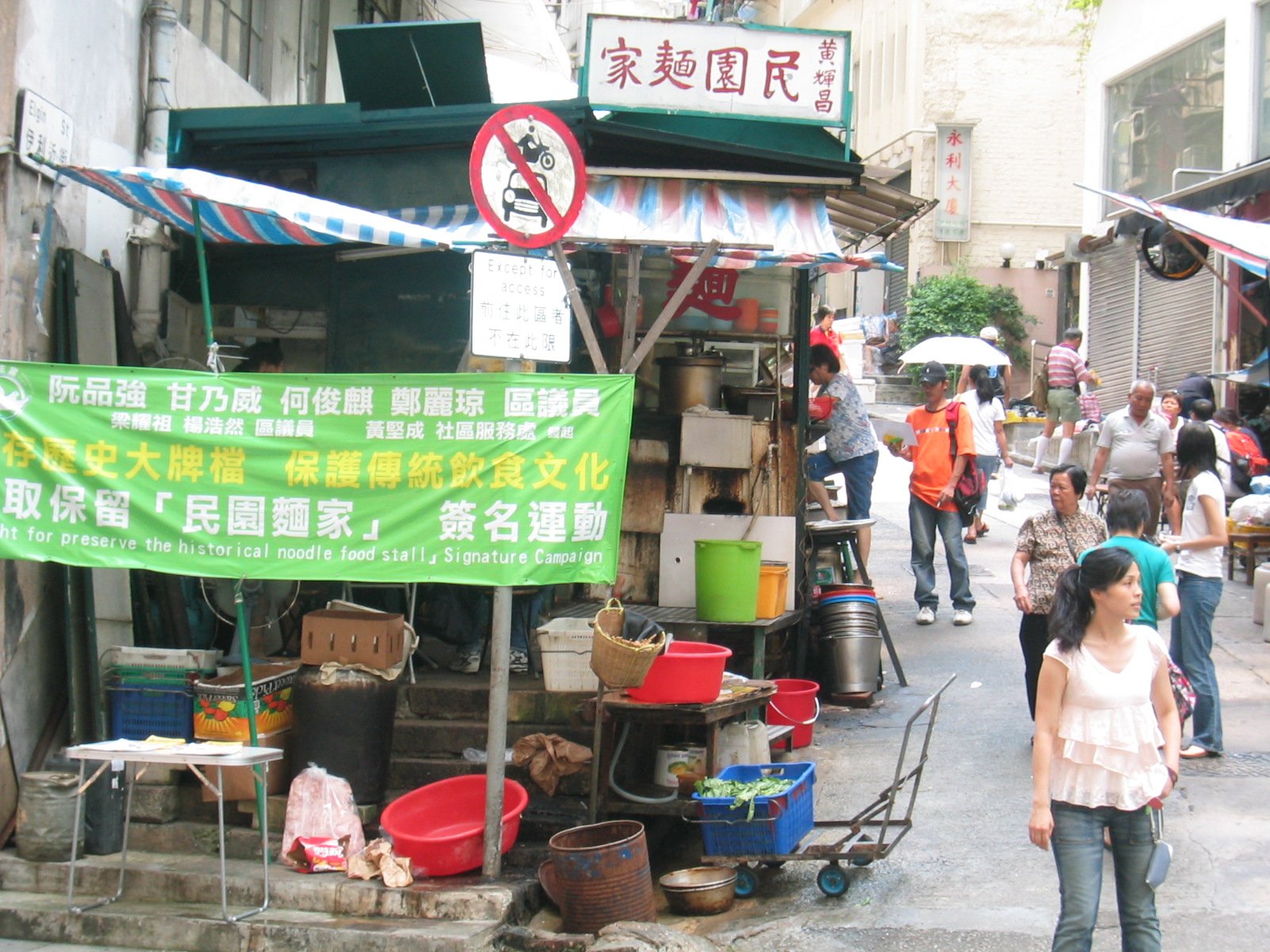 A historic Hong Kong noodle dai pai dong displaying a banner calling for its preservation