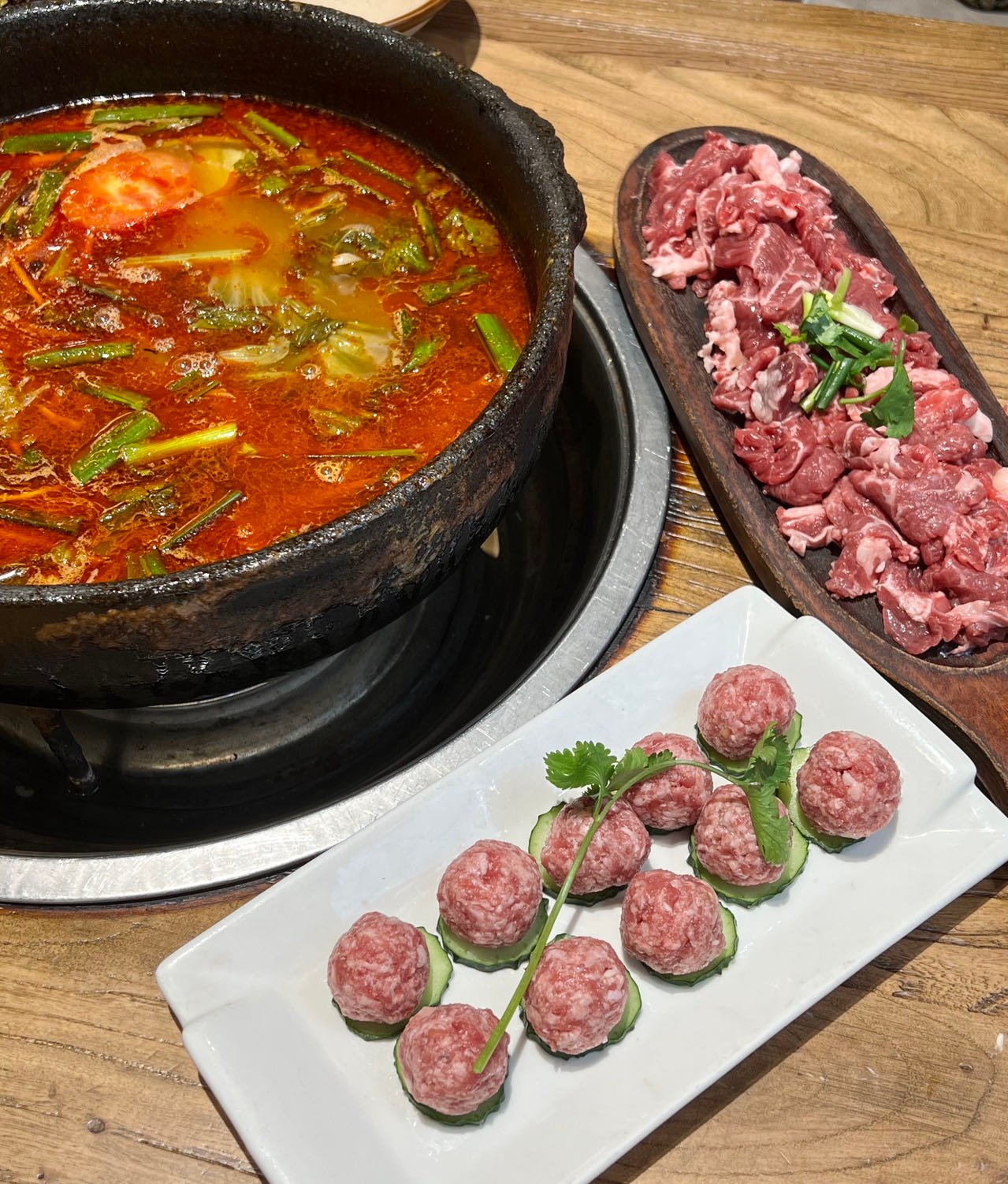 Red sour soup hotpot broth for guizhou sour soup fish, served with sliced beef and meatballs in Kaili
