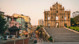Golden hour view of the Ruins of St. Paul's facade and colonial buildings in Macau's historic centre