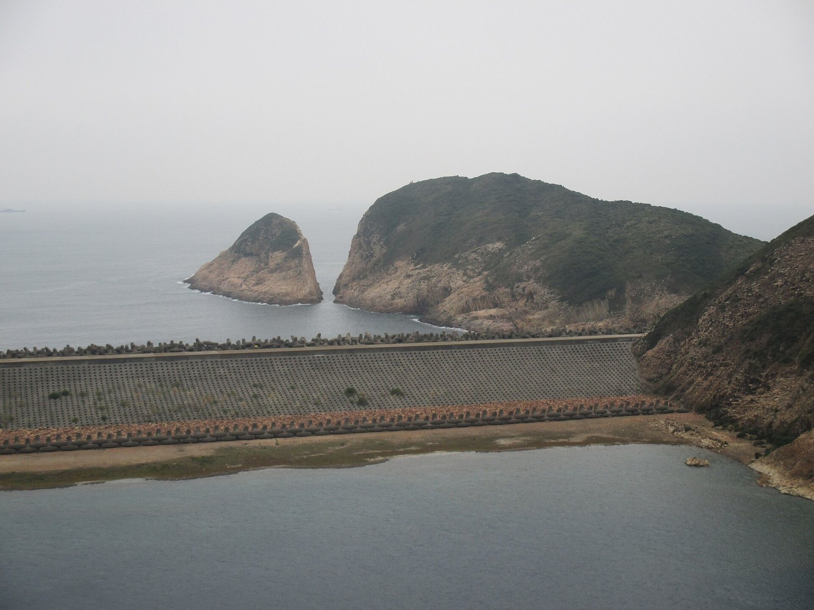 Hong Kong Geopark: Walking Among Hexagonal Stone Giants 4 The dam wall and breakwater at High Island Reservoir with Po Pin Chau in the distance