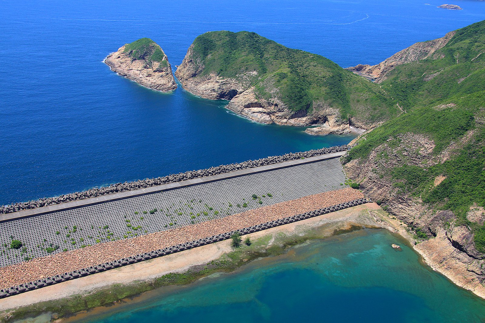 Hong Kong Geopark: Walking Among Hexagonal Stone Giants 1 Aerial view of the East Dam of High Island Reservoir with dolosse breakwater and Po Pin Chau offshore
