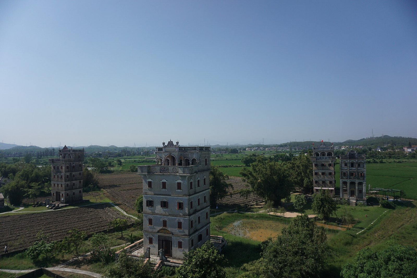 Several diaolou towers standing among rice fields in Zili Village, Kaiping
