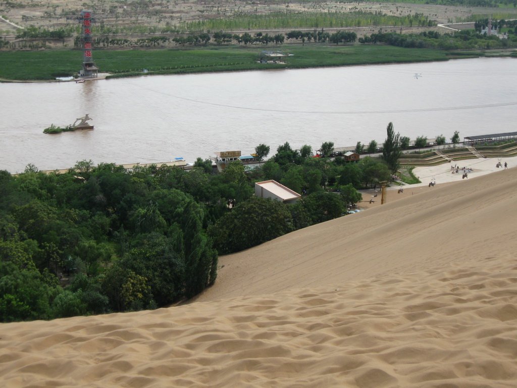 Shapotou desert and Yellow River landscape where Tengger Desert dunes drop to the water