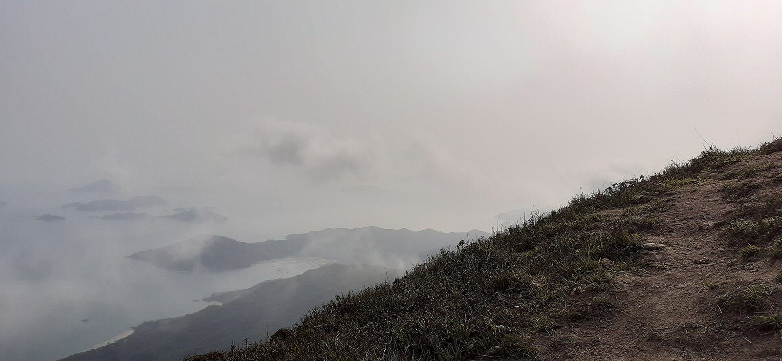 The view from the Sunset Peak ridge in cloud, with the sea and outlying islands below