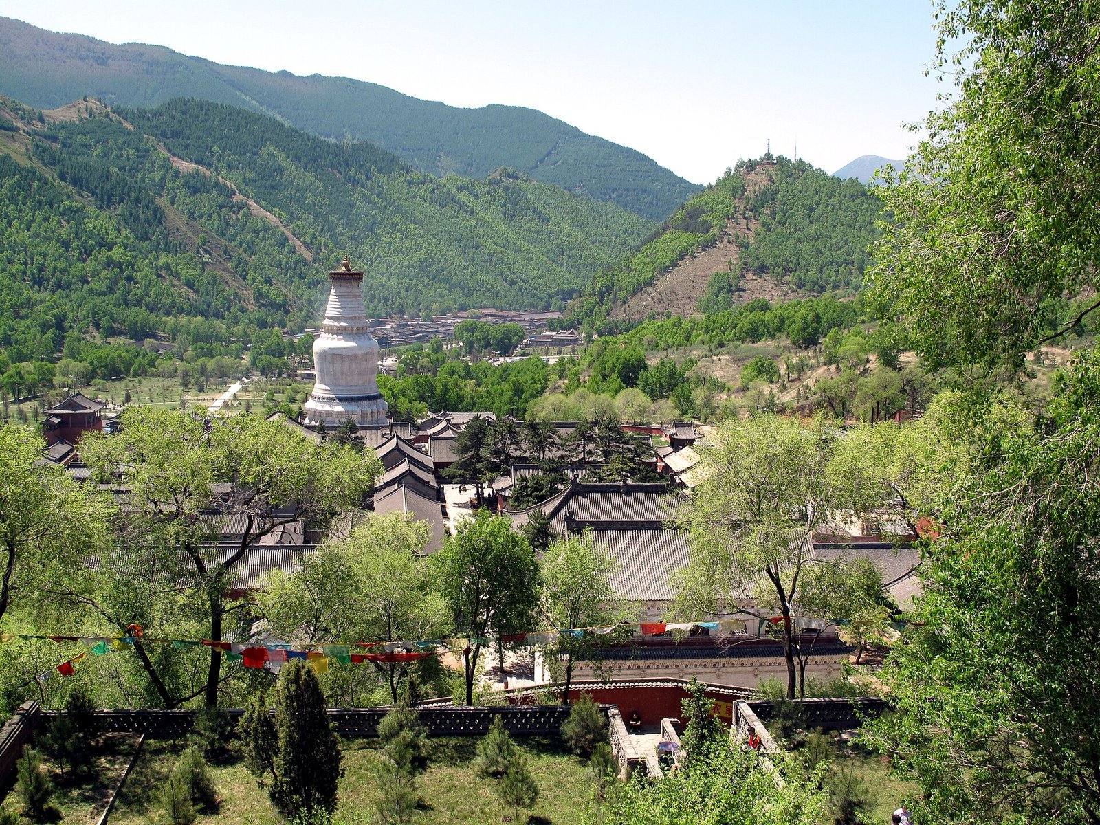 White dagoba of Tayuan Monastery rising above the temple roofs of Taihuai at Wutai Shan