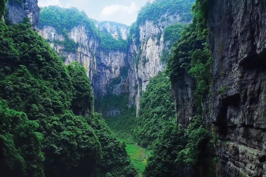Wulong's Sinkholes: Descending Into China's Karst Underworld 2 Steep vegetated limestone walls of the Wulong gorge closing overhead, seen from the valley floor