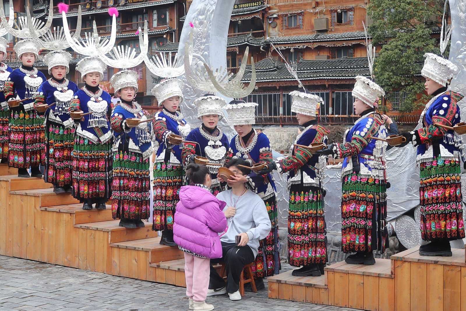 Xijiang: A Thousand Miao Households Lit Up at Dusk 3 Miao hosts pouring rice wine down a cascade of bowls during a high-mountain welcome at Xijiang